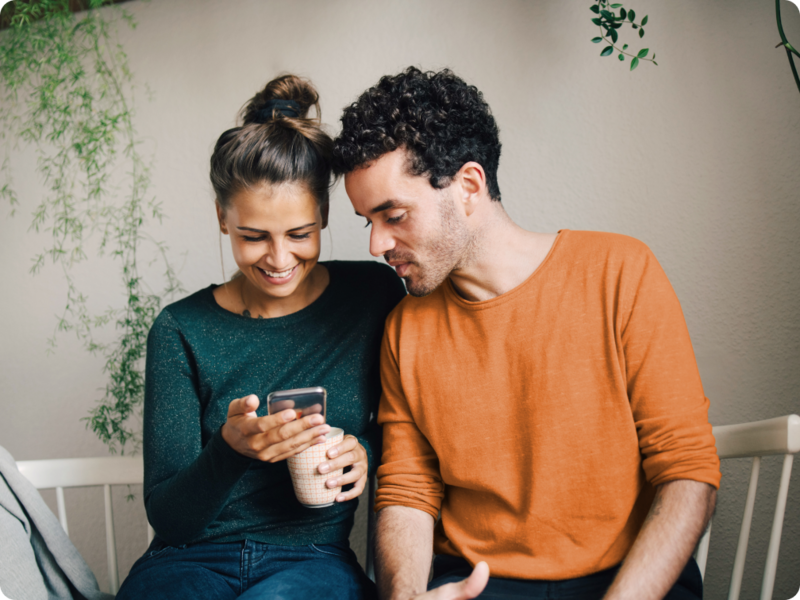 Two people use a mobile device