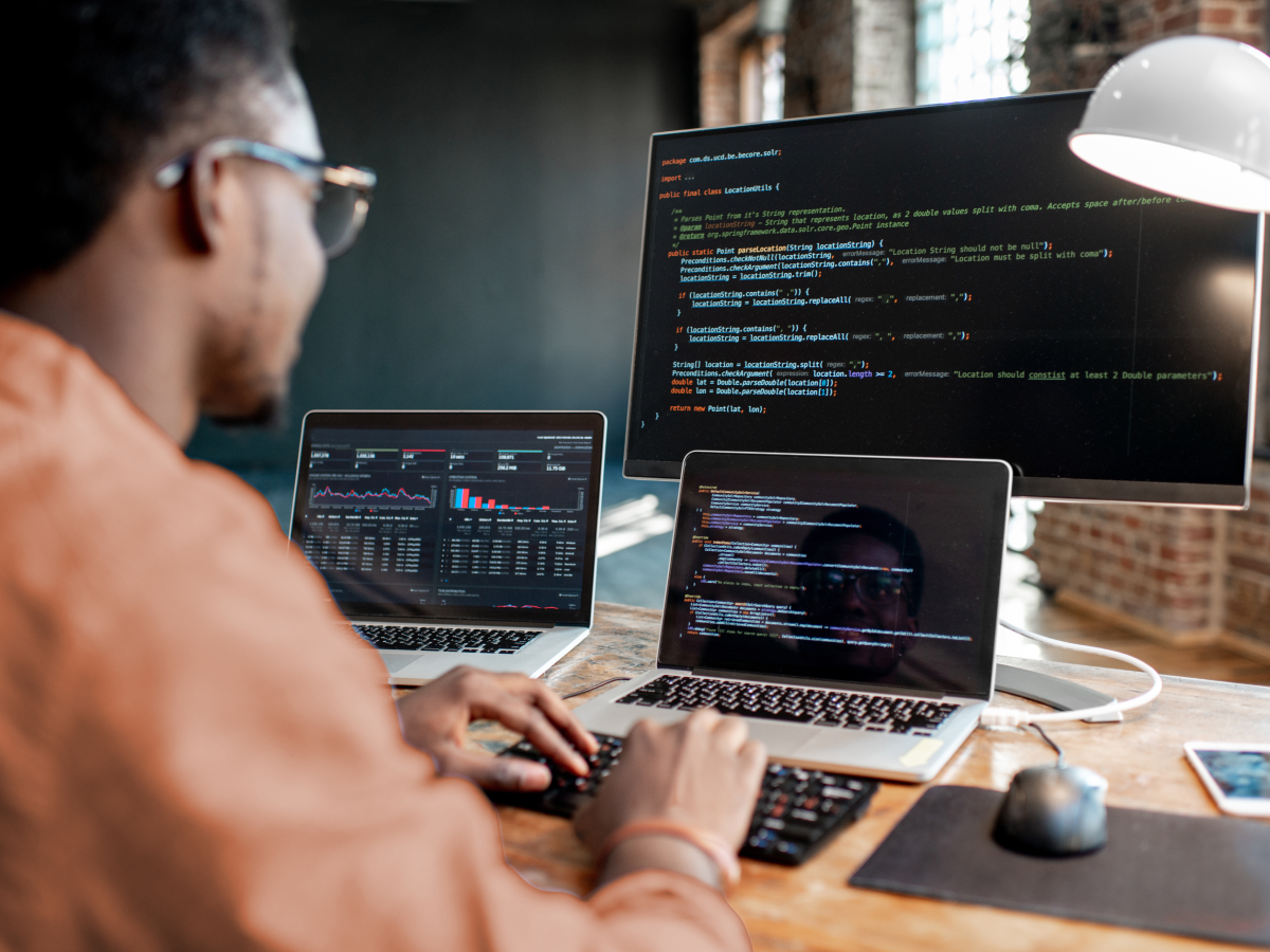 person works on software modernization on multiple screens